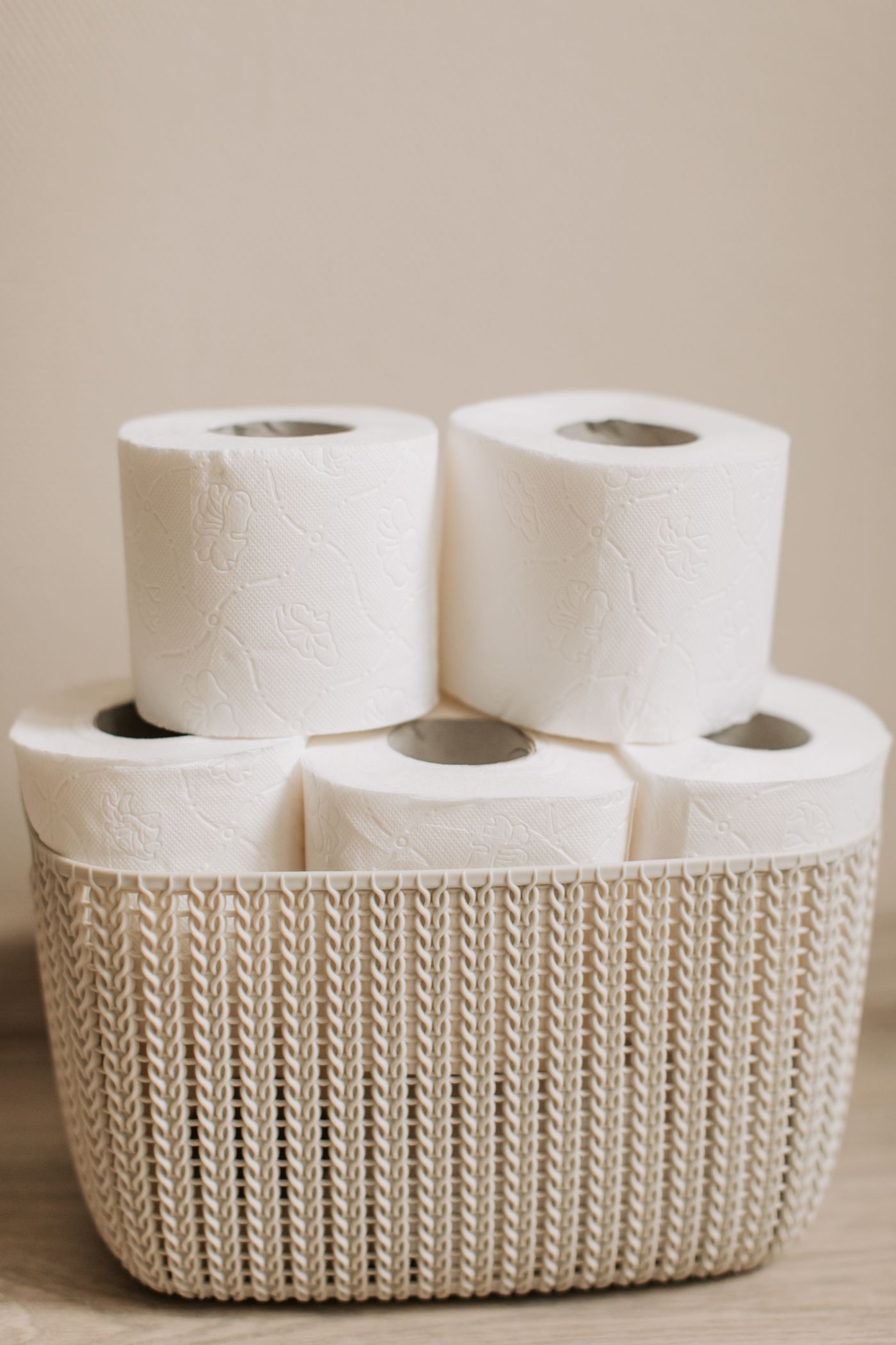 White toilet paper rolls stacked in a basket.